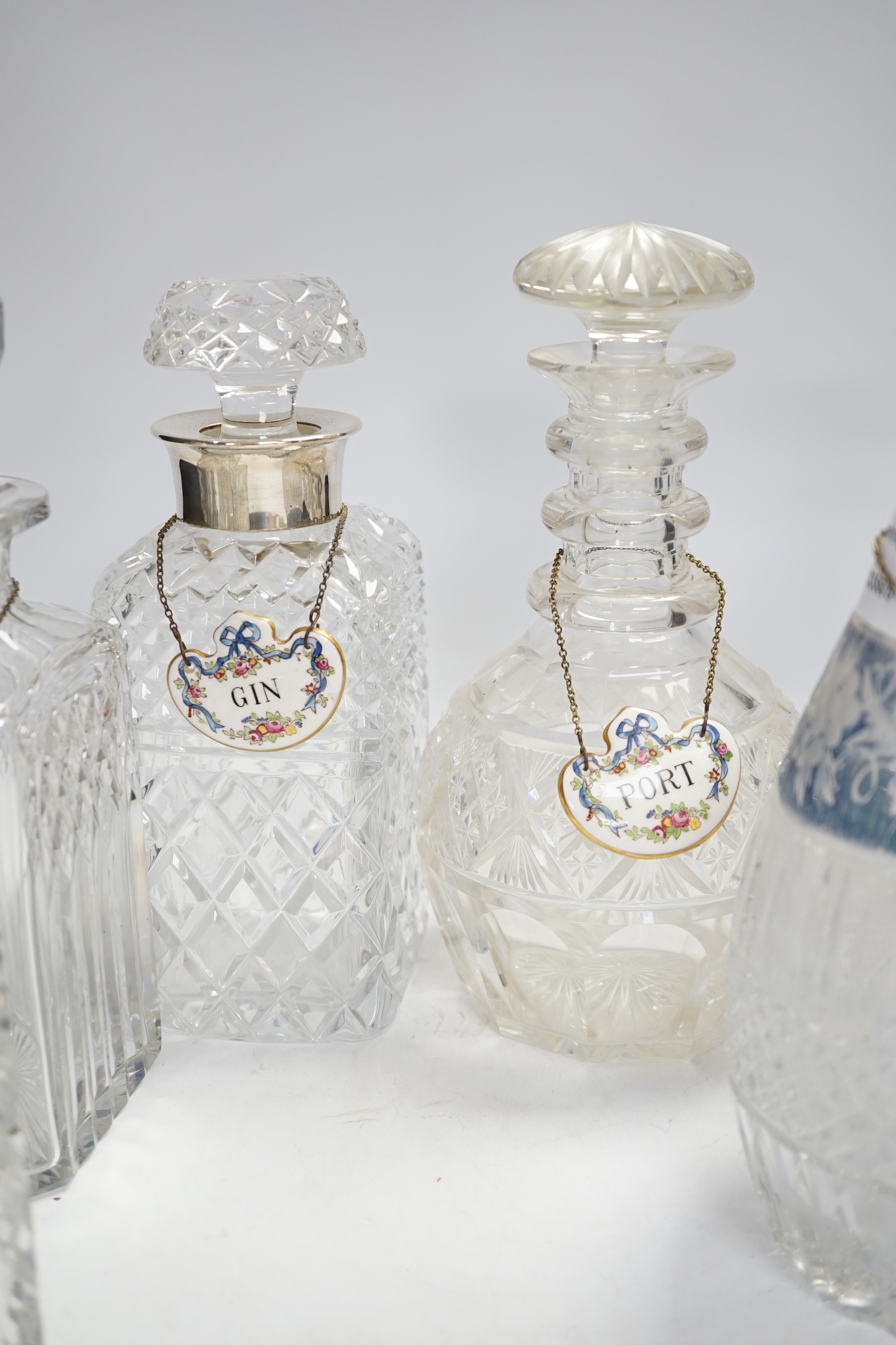 A pair of silver mounted decanters and four other decanters, five with Staffordshire decanter labels, largest 40cm high